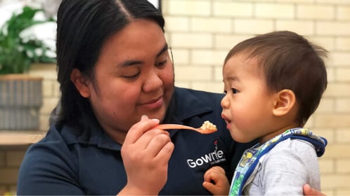 teacher is serving food to a kid