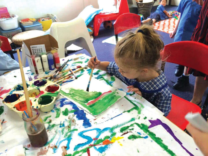 kid is drawing a colourful paint